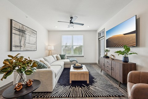 a living room with a white couch and a large window at The Quarry Luxury Apartment Homes, Fort Collins, CO